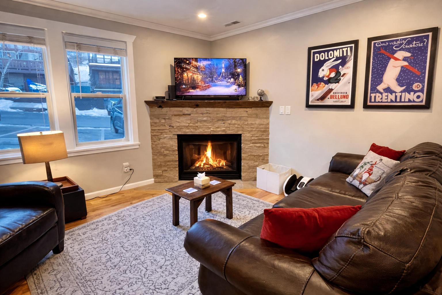 Unwind in the cozy living room with a stunning stone fireplace, large leather sectional sofa, and smart TV.