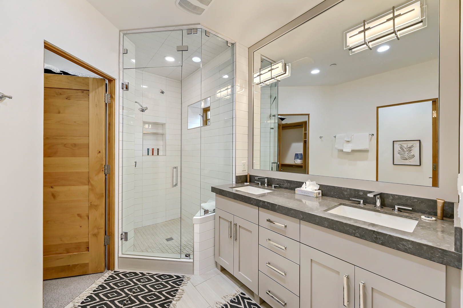 Step into your serene retreat, where a spa-inspired glass shower, dual vanities, and warm wood accents create the perfect space for unwinding after a mountain adventure.