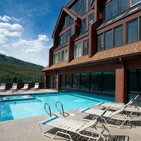 Relax on the sunny pool deck featuring comfortable lounge chairs and enjoy the expansive mountain views. This amenity provides a perfect spot to unwind and soak up the sun during your stay.
