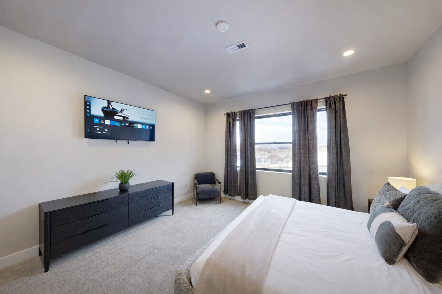 Unwind in your spacious bedroom with modern amenities and peaceful views through large windows.