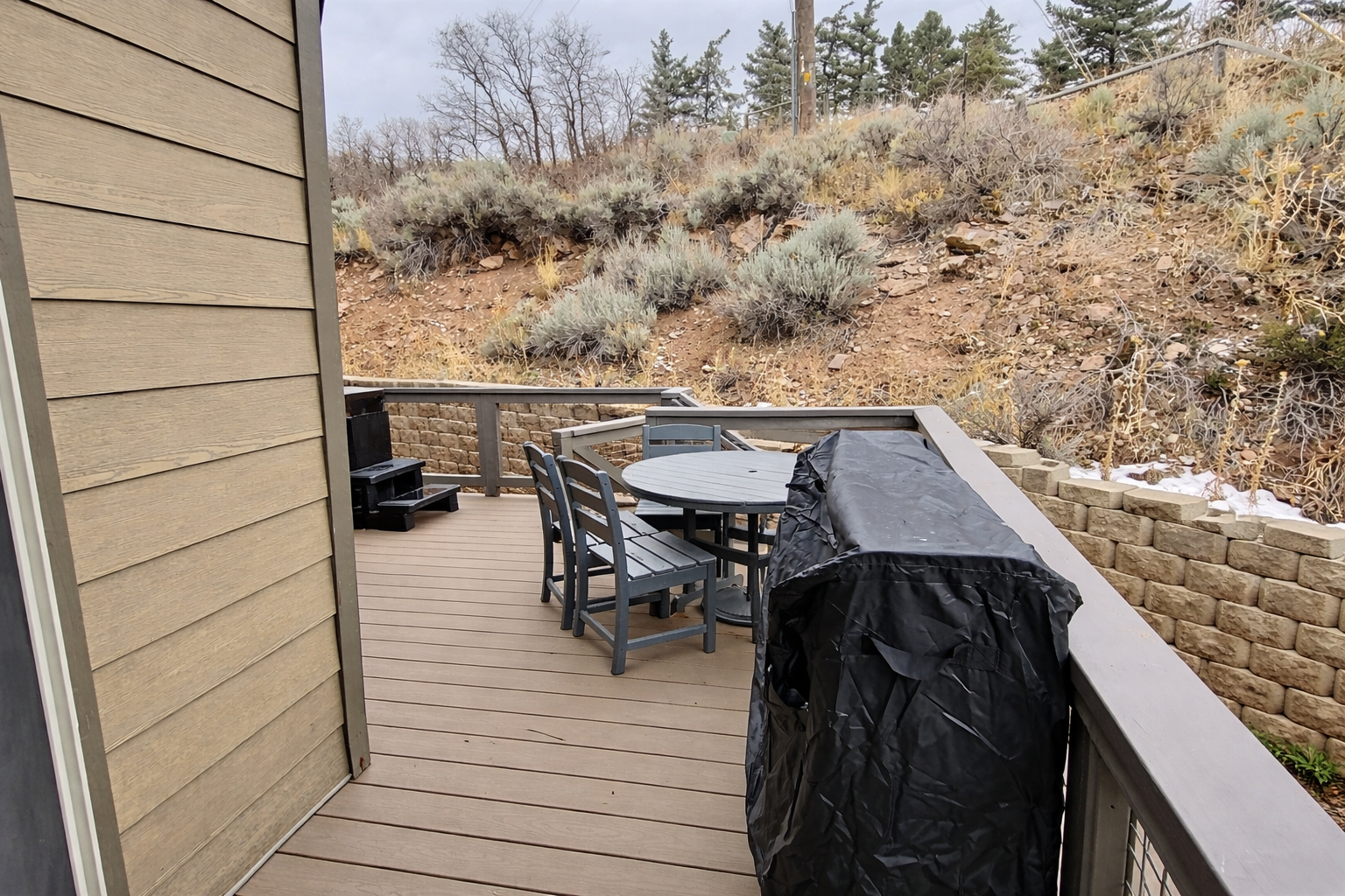 The deck overlooks a natural hillside dotted with sage and native grasses, offering a quiet, elevated perch for your morning coffee or evening conversation.