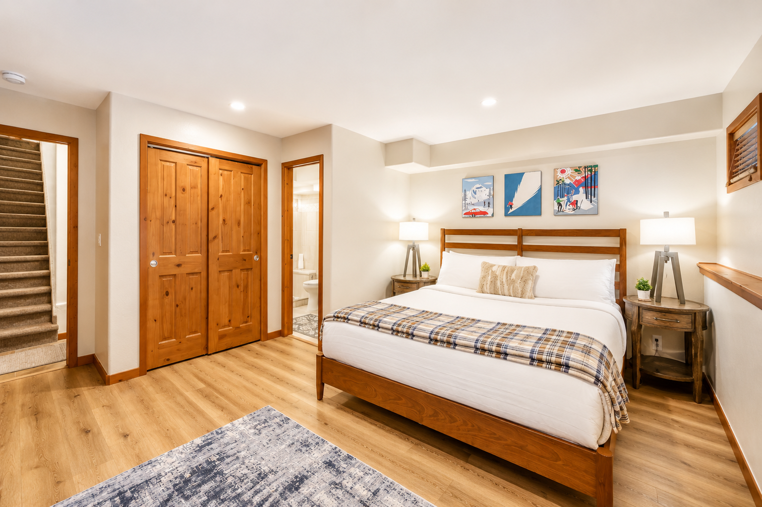 Your cozy bedroom features warm wood tones, crisp linens, and thoughtful touches like vintage ski art to help you unwind after a day on the mountain.