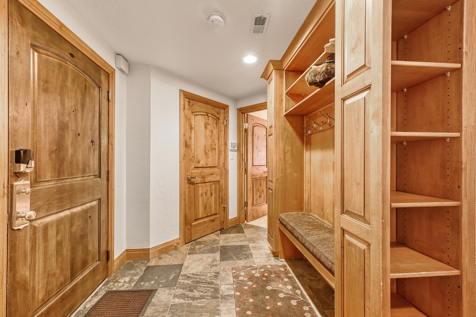 Your private mudroom awaits with custom wood storage, built-in bench seating, and organized cubbies for your gear after mountain adventures.