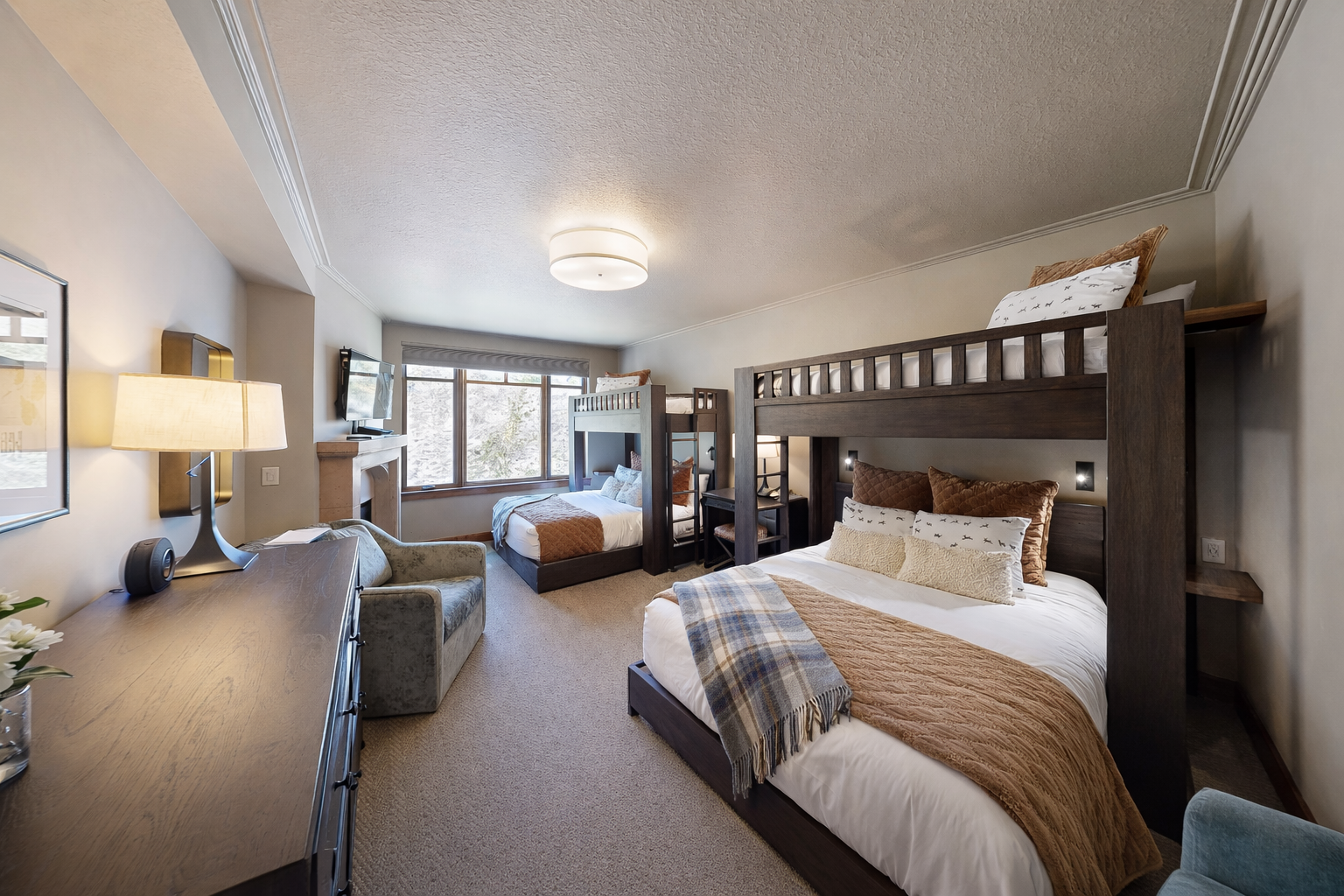 Your spacious bedroom features cozy bunk beds and a comfortable queen bed, perfect for families seeking restful mountain retreat accommodations.