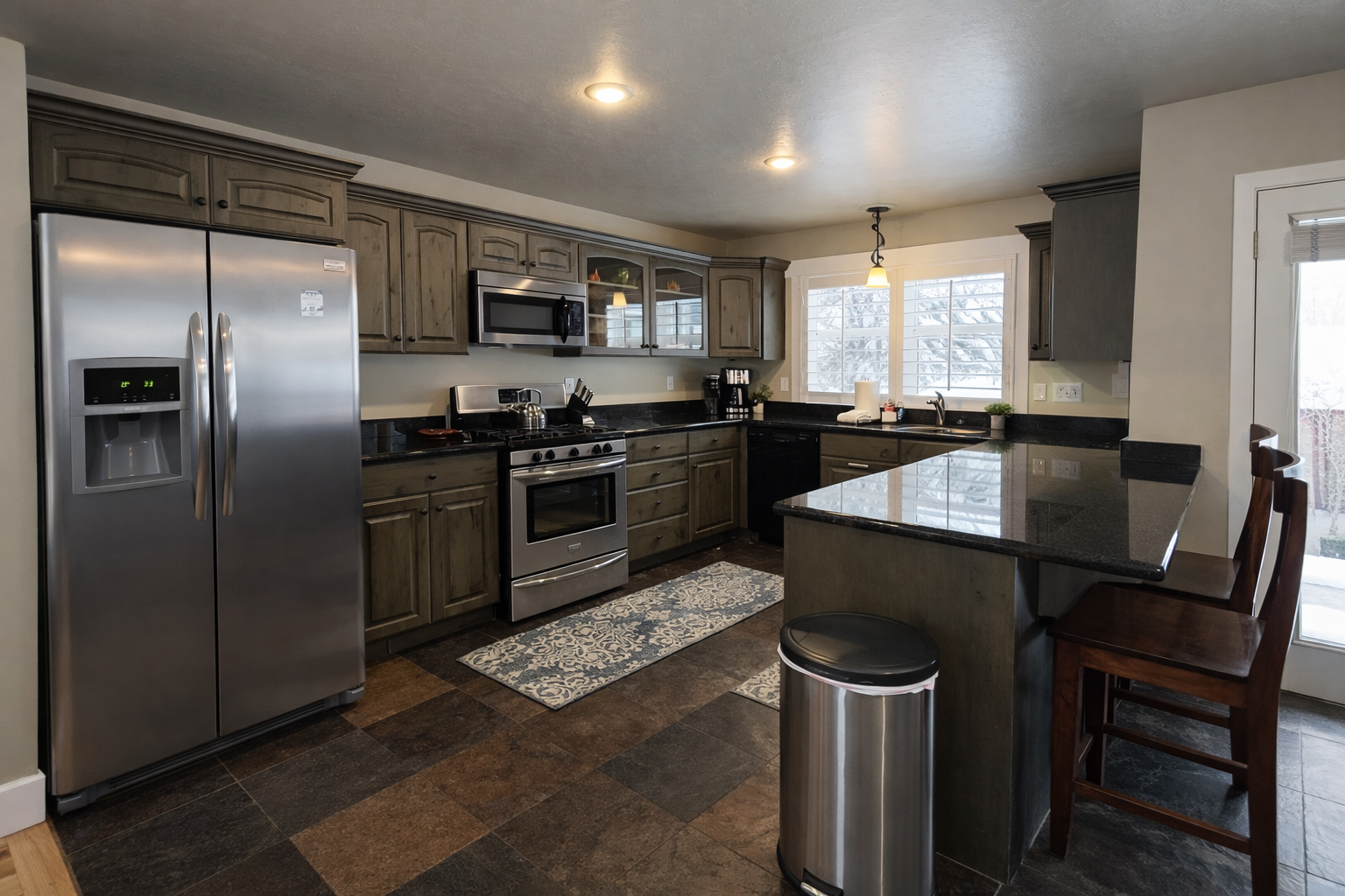 Step into your fully equipped kitchen featuring sleek granite countertops, stainless steel appliances, and a convenient breakfast bar for casual dining.