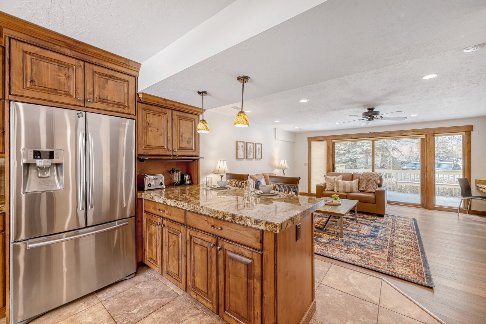 Your fully equipped kitchen features granite countertops, stainless appliances, and flows seamlessly into the cozy living area with mountain views.