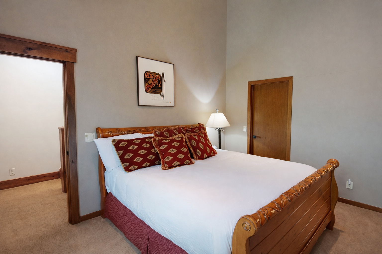 Sink into crisp white linens in your cozy bedroom with warm wood accents and soft lighting creating the perfect retreat.