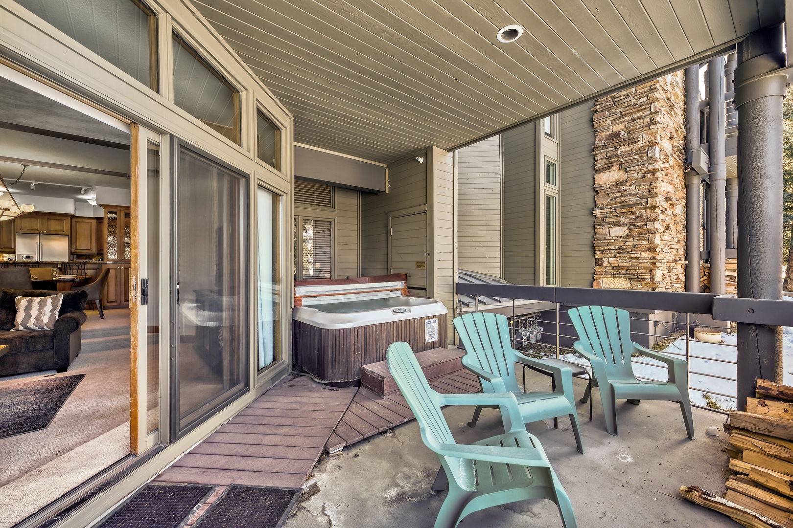 Relax on your private covered deck with bubbling hot tub and colorful Adirondack chairs, perfect for soaking and unwinding after mountain adventures.