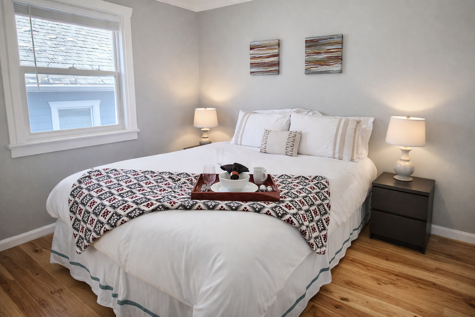 Sink into crisp white linens and enjoy morning coffee in this serene bedroom, where warm lighting and thoughtful touches create your perfect retreat.