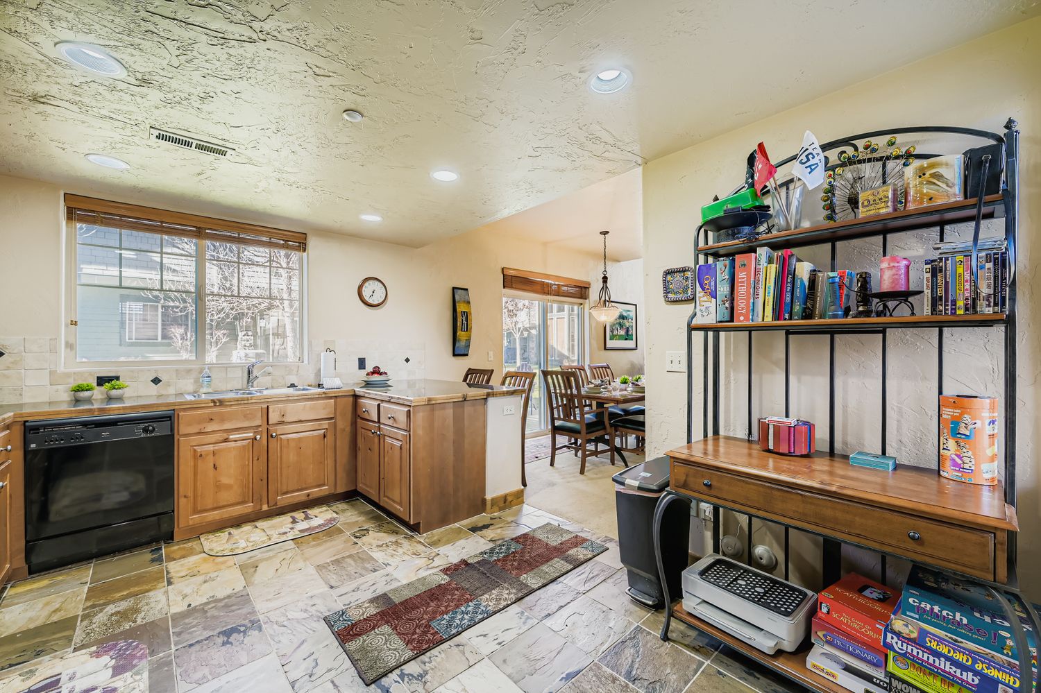 Your open-concept kitchen and dining space features warm wood cabinets, modern appliances, and a cozy library corner with games and books for relaxing evenings.