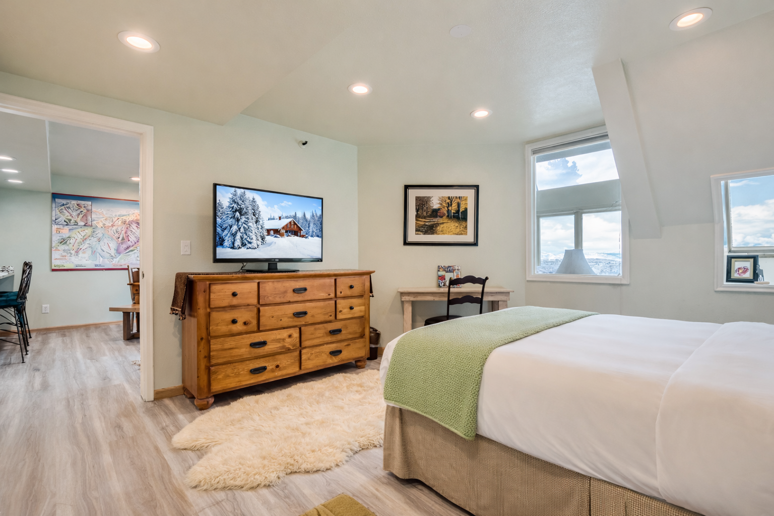 Sink into comfort in your serene bedroom with soft green accents, natural wood furnishings, and your own private bathroom sanctuary.