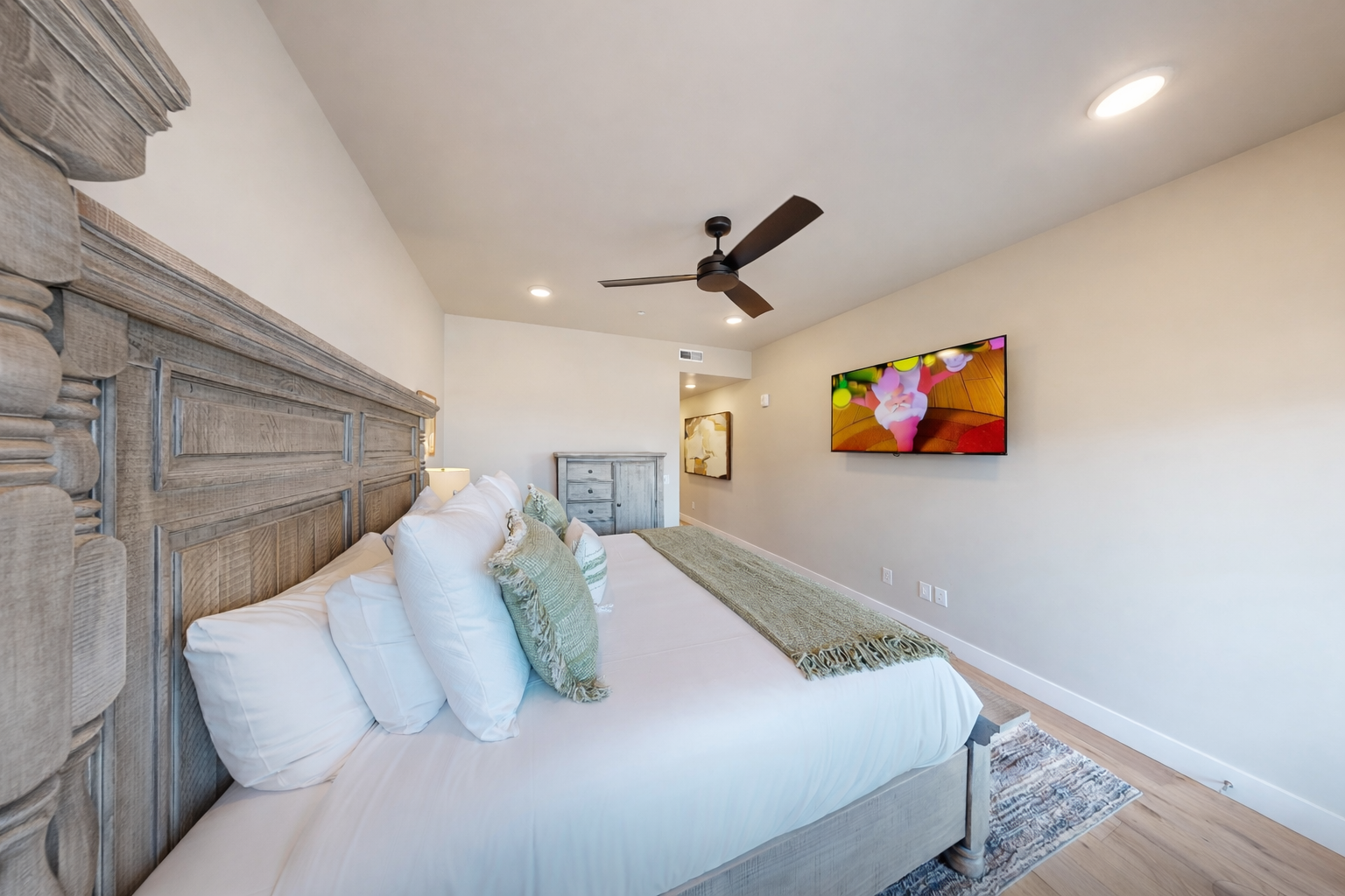 Relax in this bright, modern bedroom featuring a plush king bed and sleek wooden accents. A serene mountain retreat with large windows—perfect for your next Park City adventure.