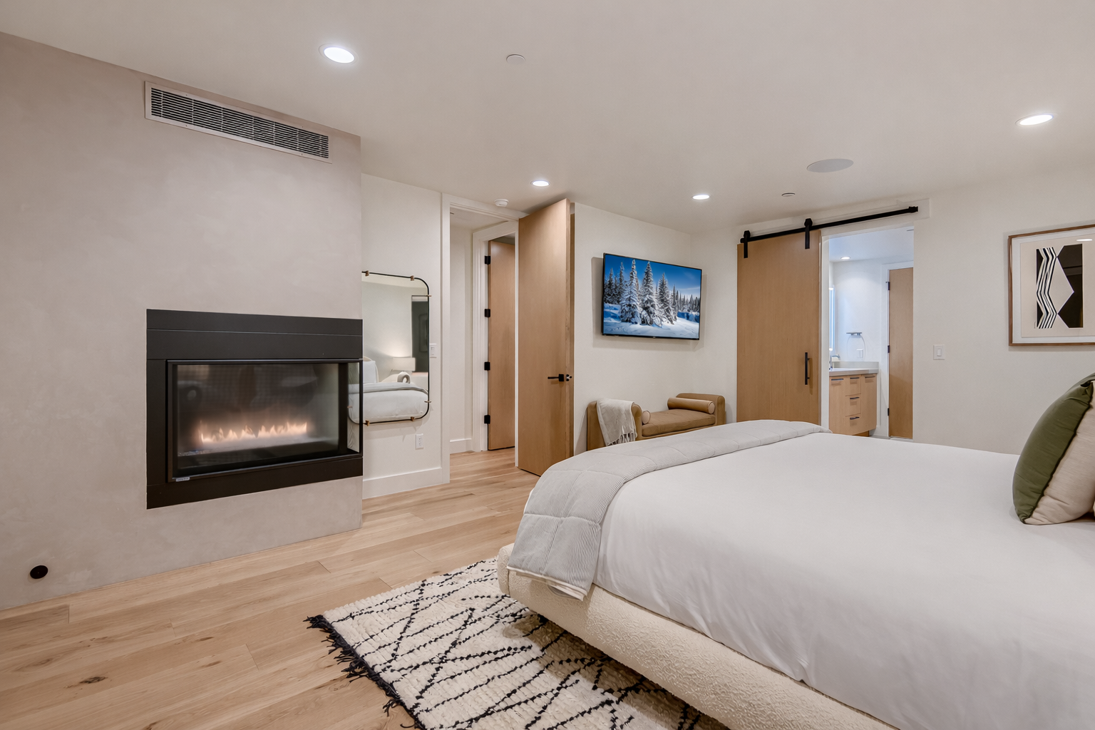 Retreat to the elegant primary suite with a plush king-size bed, a warm fireplace, and direct access to your private ensuite bathroom.