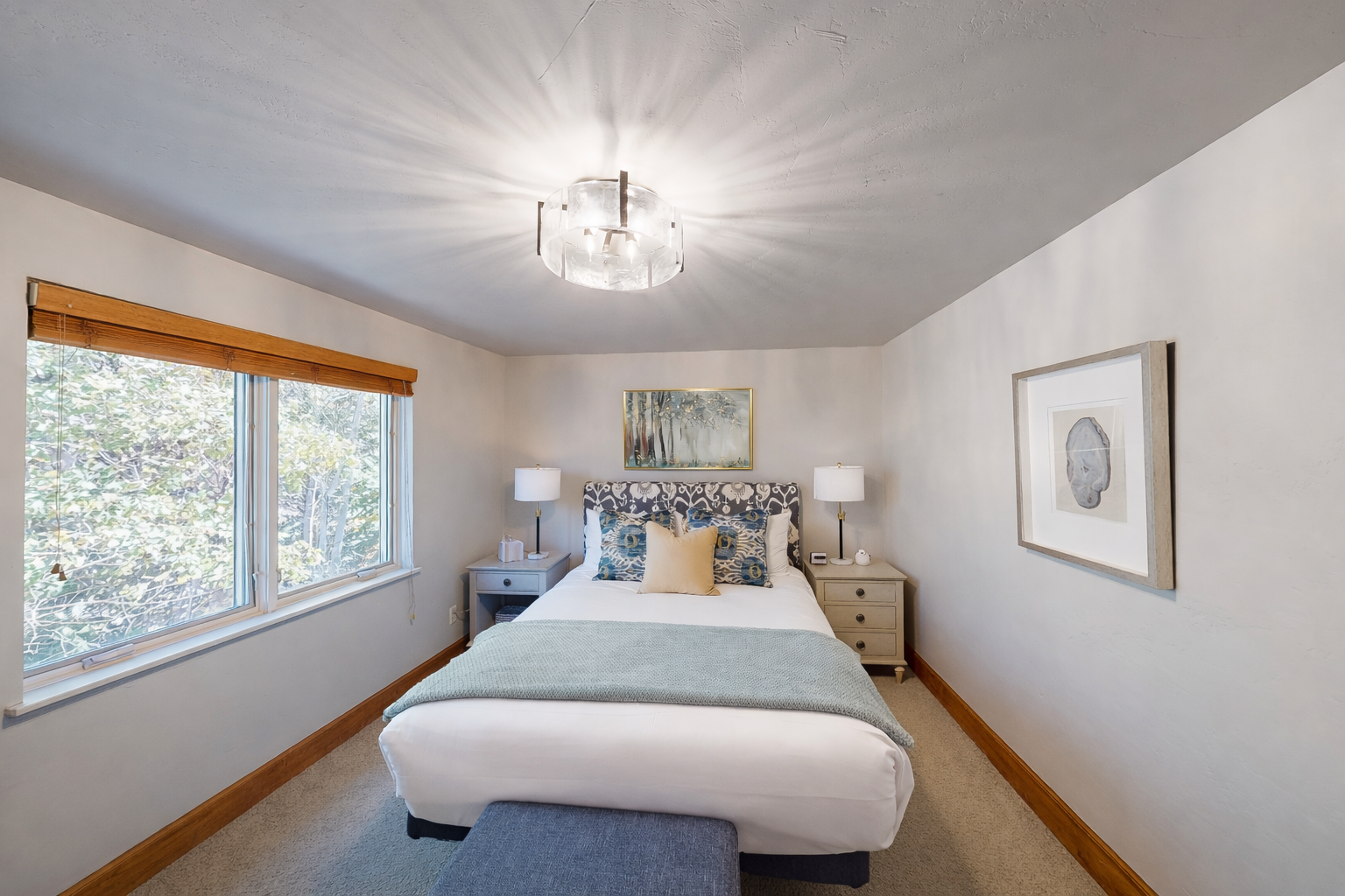 Drift off to peaceful sleep in your cozy queen bedroom, surrounded by warm wood trim and gentle natural light filtering through treetop views.