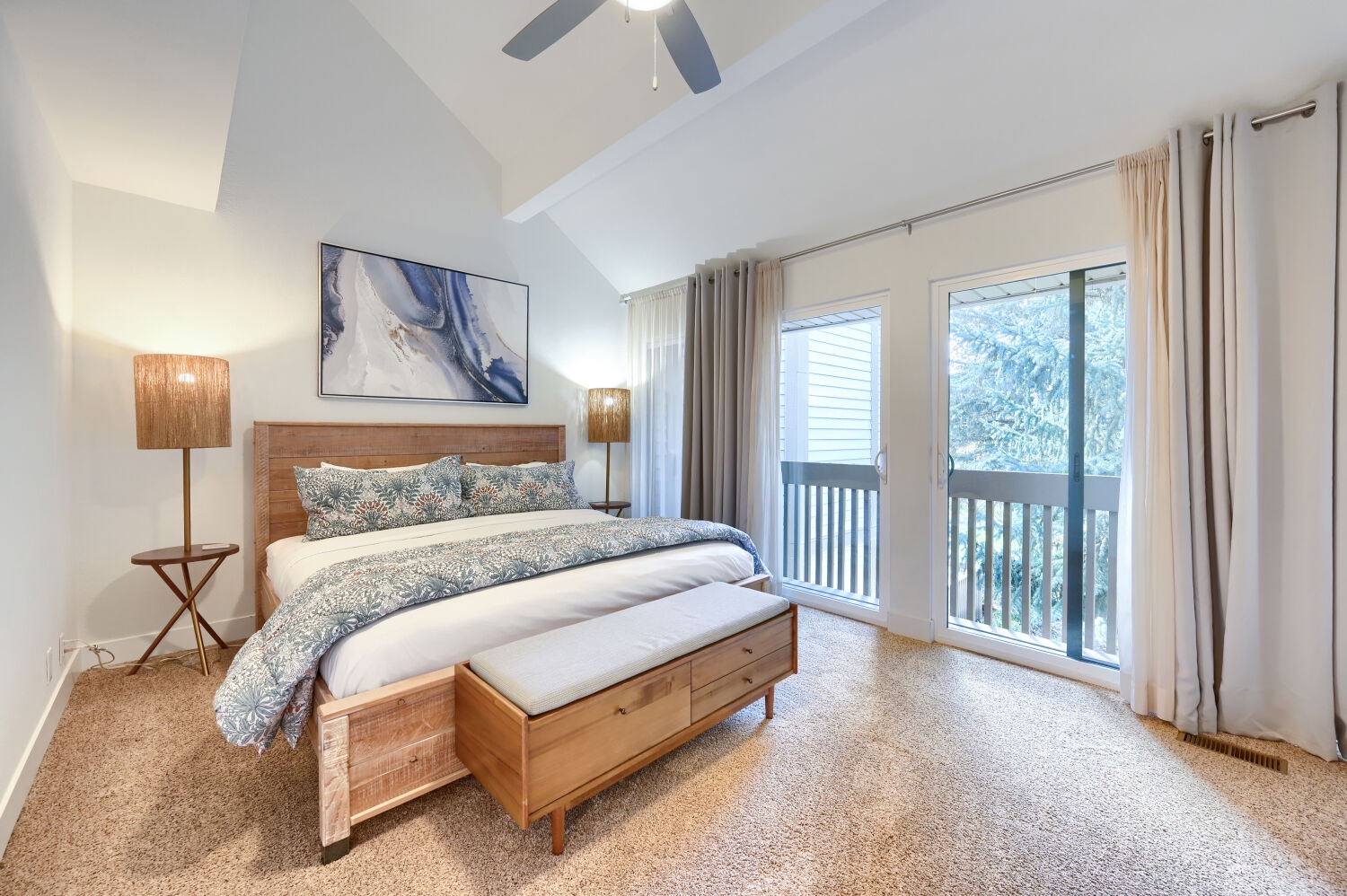 Wake up refreshed in your serene bedroom, where soft morning light filters through the balcony doors and a plush bed invites restful sleep beneath vaulted ceilings.