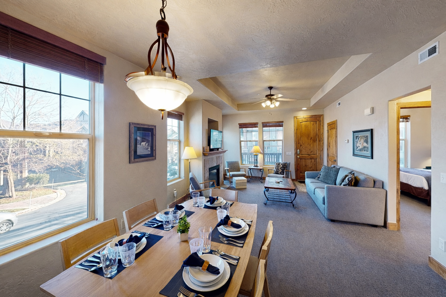 Relax in your open-plan living space where the dining table flows seamlessly into the cozy living room with fireplace and mountain views.