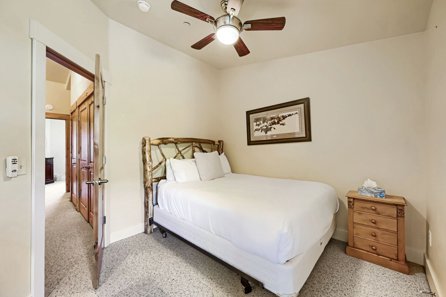 Drift off to sleep in this cozy bedroom with crisp linens, rustic wood details, and a ceiling fan keeping you comfortable all night.