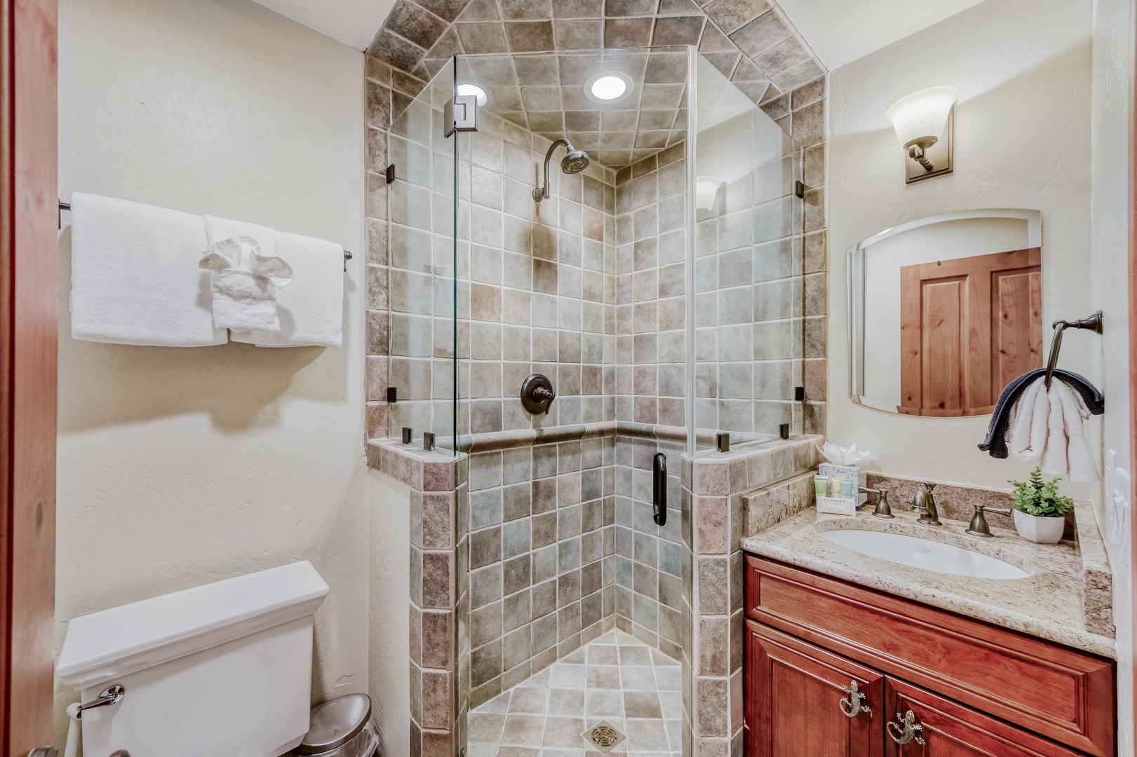 Relax in the spacious walk-in shower with a glass enclosure, and utilize the ample counter space on the elegant wooden vanity.