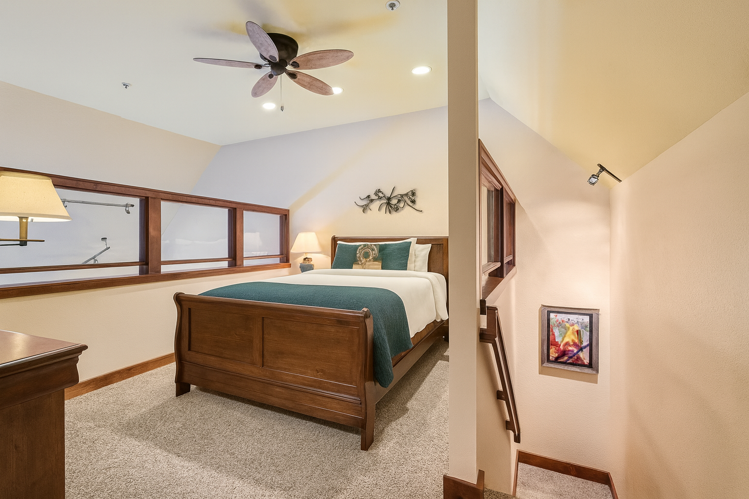 Cozy loft bedroom with a plush queen bed, warm lighting, and rustic wood furnishings. Overlooks the living area and offers a peaceful retreat after skiing or exploring Park City. Bright, inviting, and perfect for a comfortable mountain getaway.