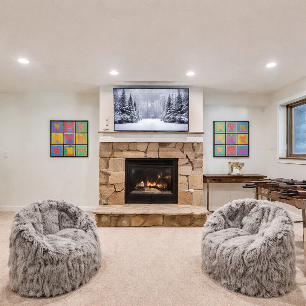 Enjoy our fun game room featuring comfortable seating, a TV, and a foosball table. Perfect for relaxing with family and friends next to the warm stone fireplace.