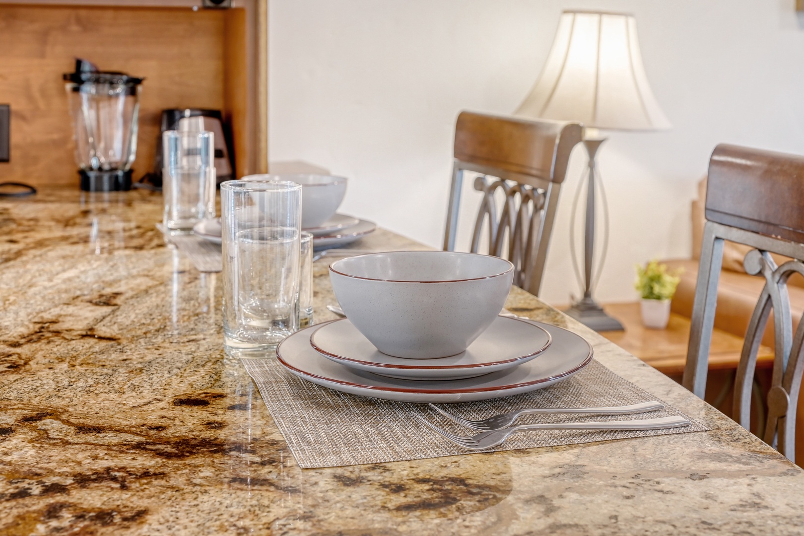 Gather around your fully equipped kitchen island where granite countertops and thoughtful dishware await your culinary adventures.