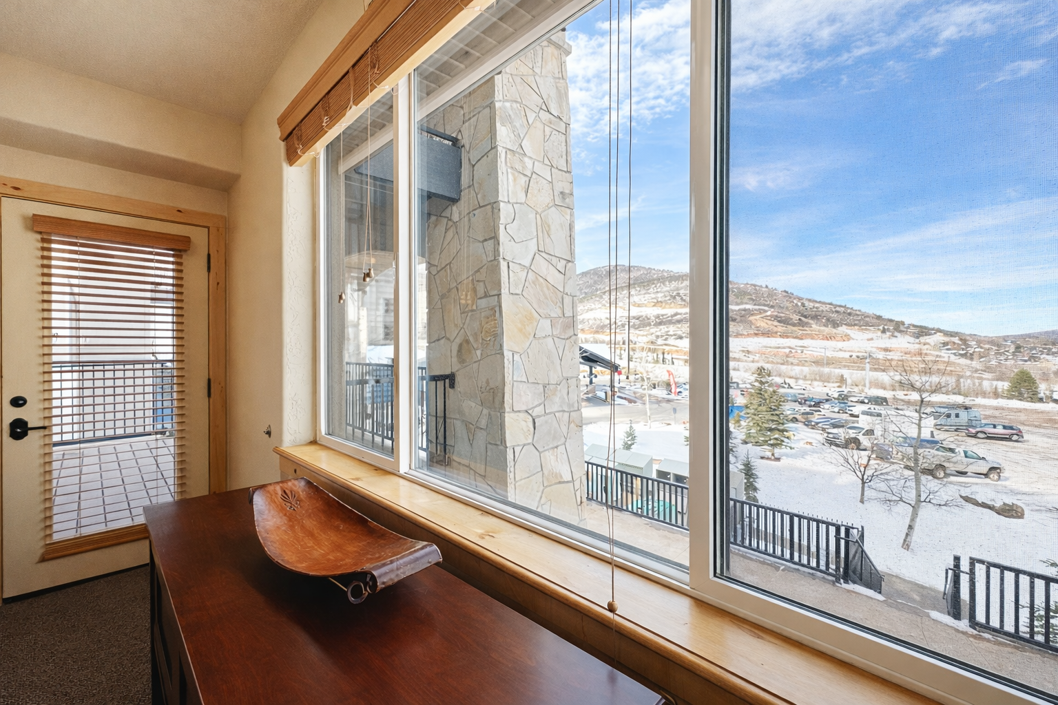 Relax at your private window nook with breathtaking mountain views and cozy wooden details that frame your winter getaway perfectly.