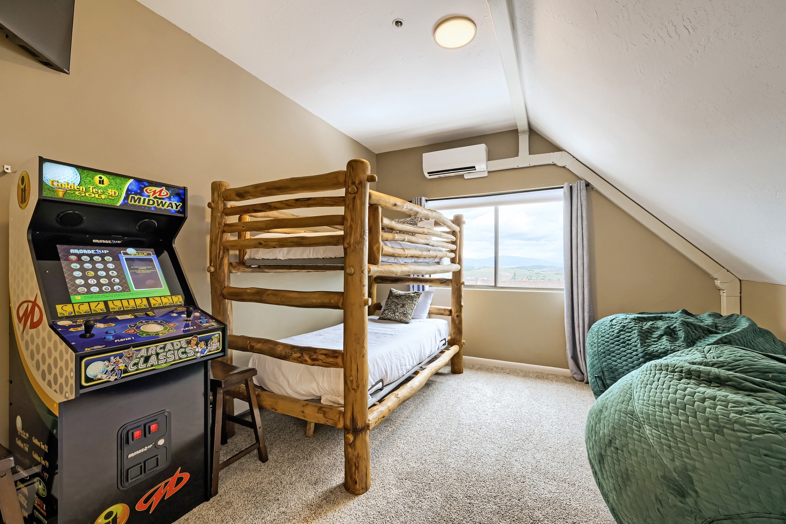 Your kids will love this fun bedroom with rustic bunk beds, cozy twin bed, and a classic arcade game—perfect for playtime after exploring the area.