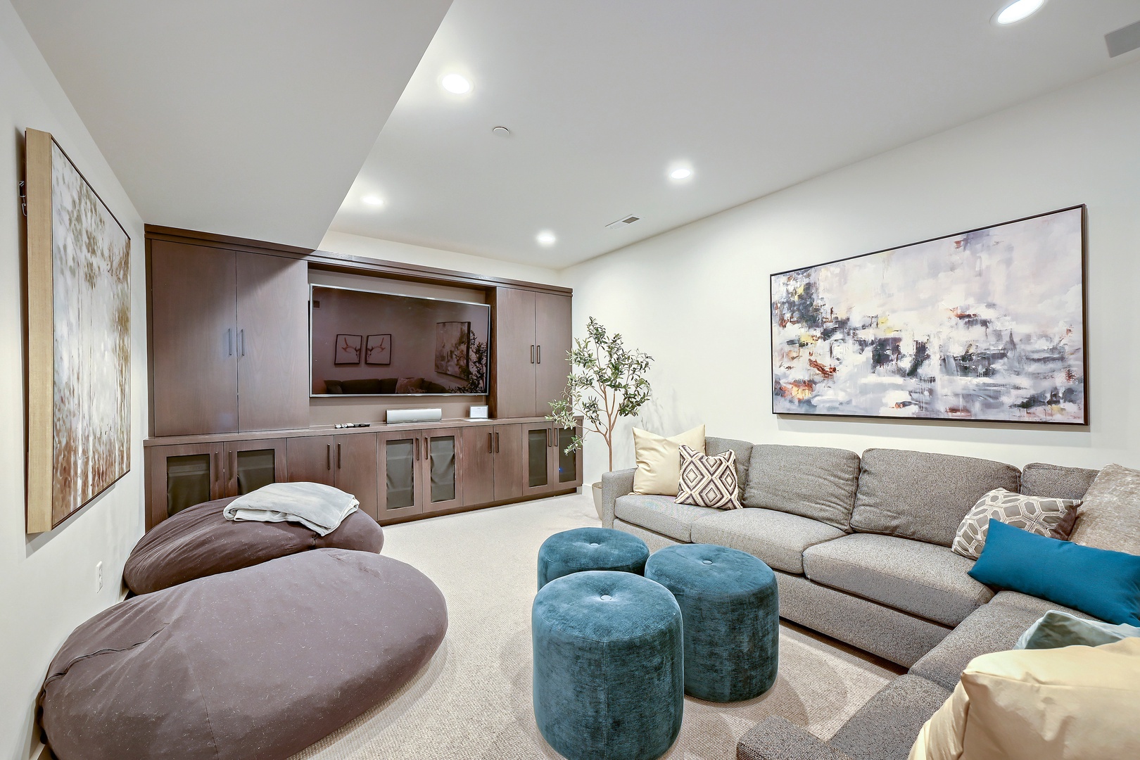 Unwind in your private lounge with plush seating, modern art, and a sleek entertainment center—perfect for cozy movie nights or relaxing with a book.