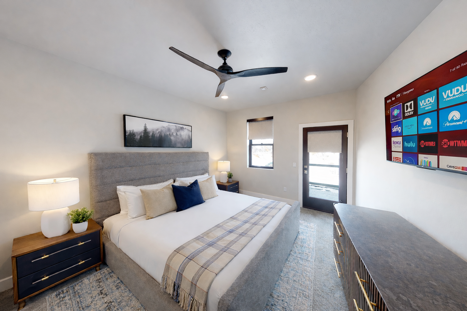 Retreat to this tranquil, modern primary suite featuring a plush king-sized bed with a stylish channeled headboard. Soft, neutral tones and a spacious layout create a serene sanctuary for your ultimate relaxation.