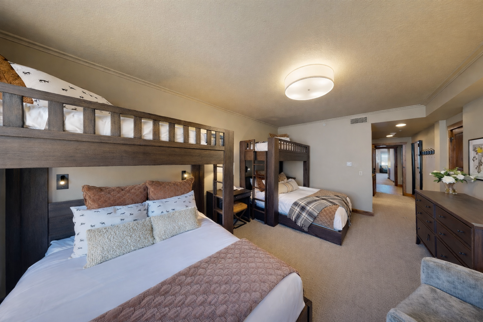 Your spacious bedroom features cozy bunk beds and a comfortable queen bed, perfect for families seeking restful mountain retreat accommodations.