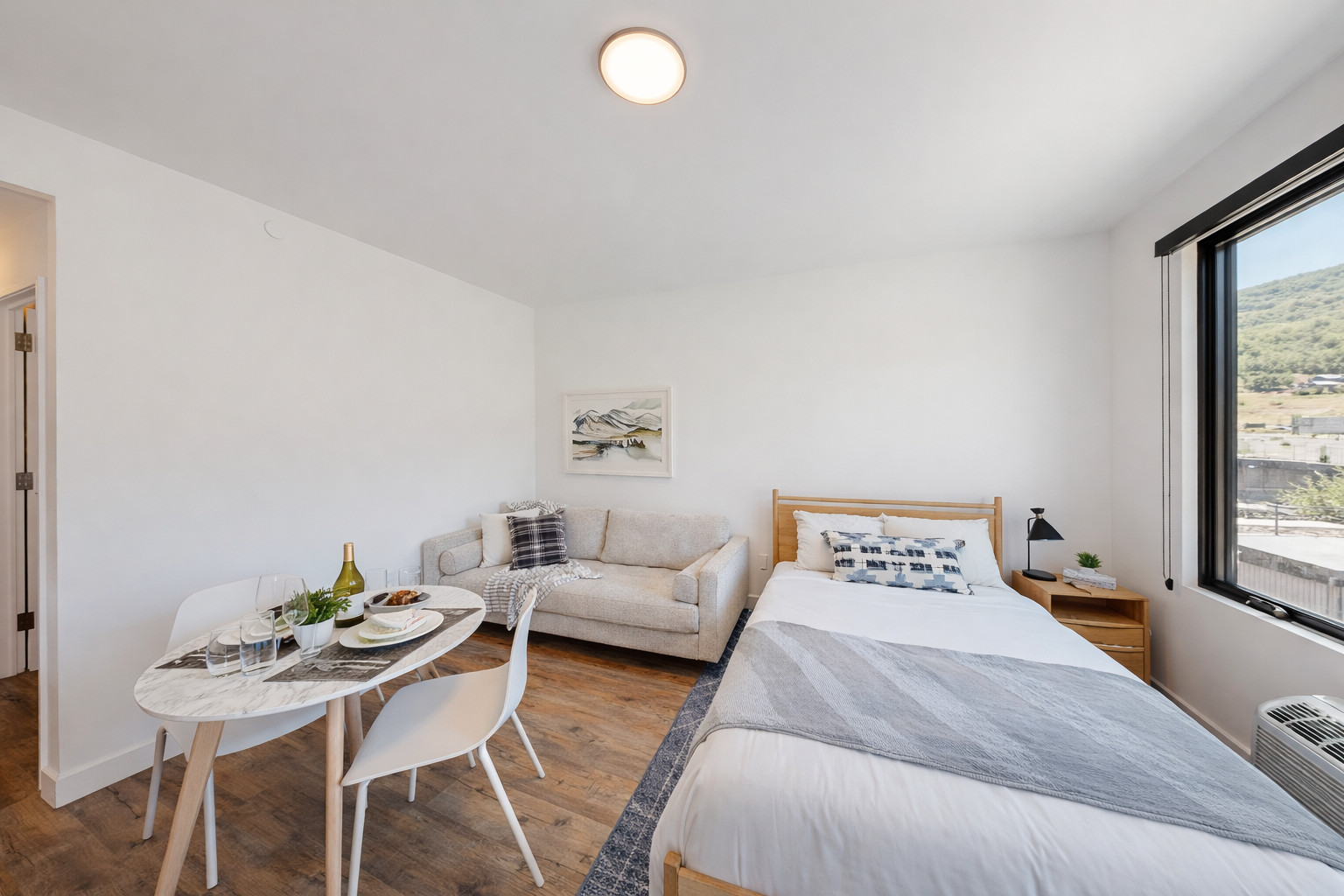 Your bright studio combines comfort and style with a cozy bed, modern seating area, and dining space perfect for unwinding.