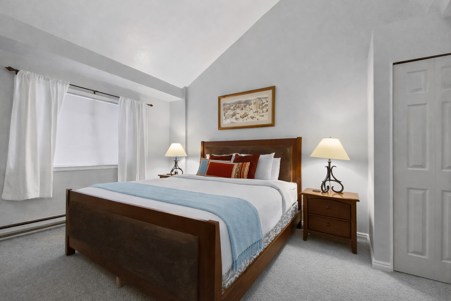 Peaceful guest bedroom featuring a comfortable bed, ceiling fan, and lovely artwork. A tranquil retreat for a restful stay in the mountains.