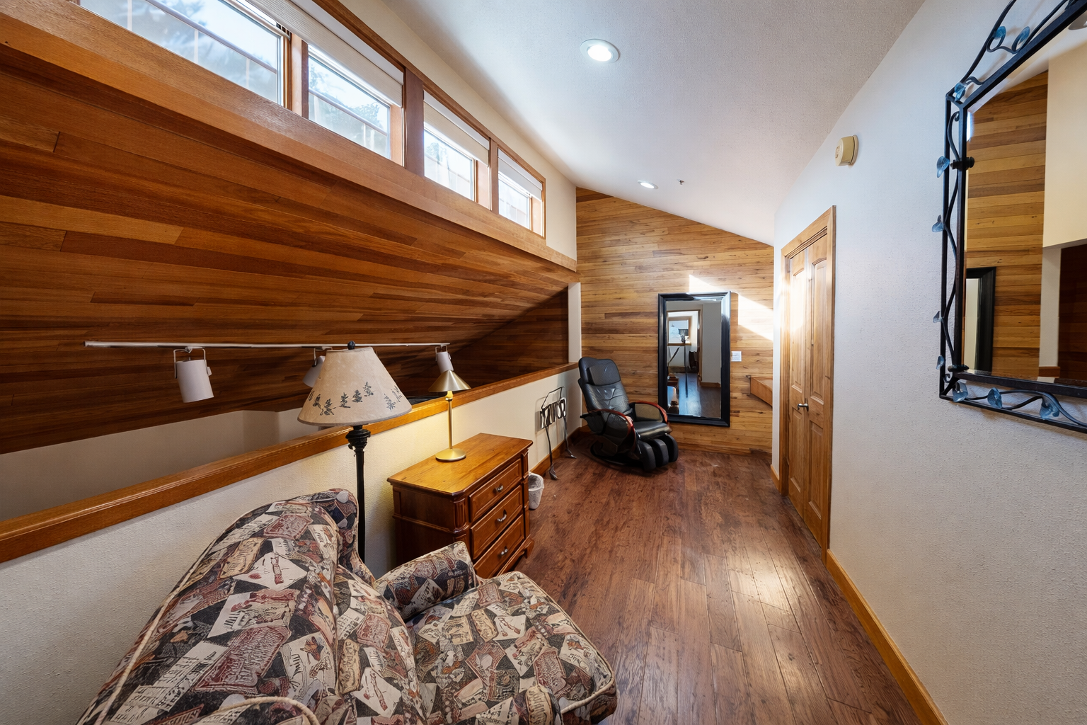 Your private loft sitting features warm wood details, cozy seating, and peaceful natural light streaming through clerestory windows.