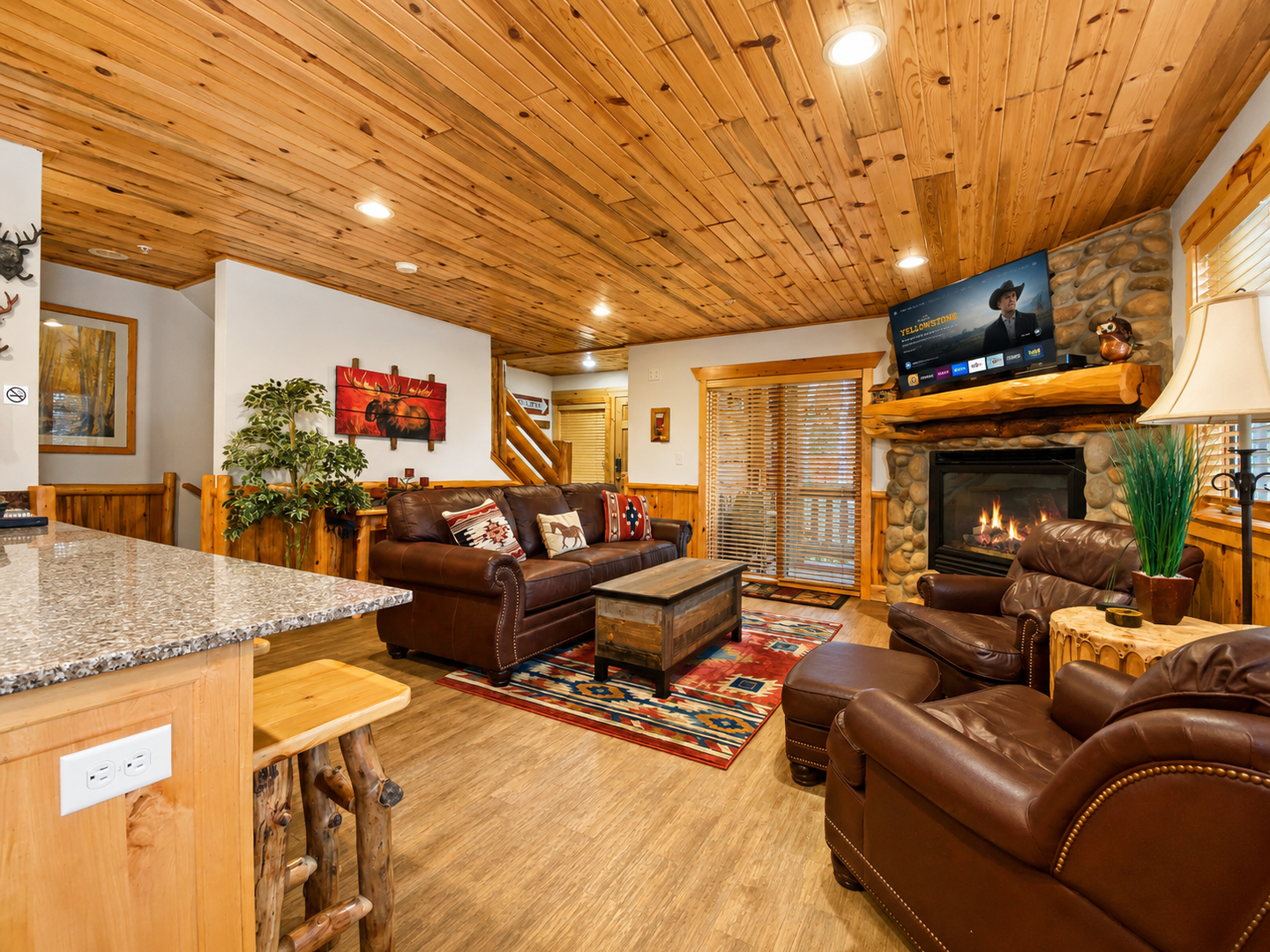 Cozy mountain retreat featuring a warm stone fireplace, fully equipped kitchen with granite countertops, and spacious living areas.
