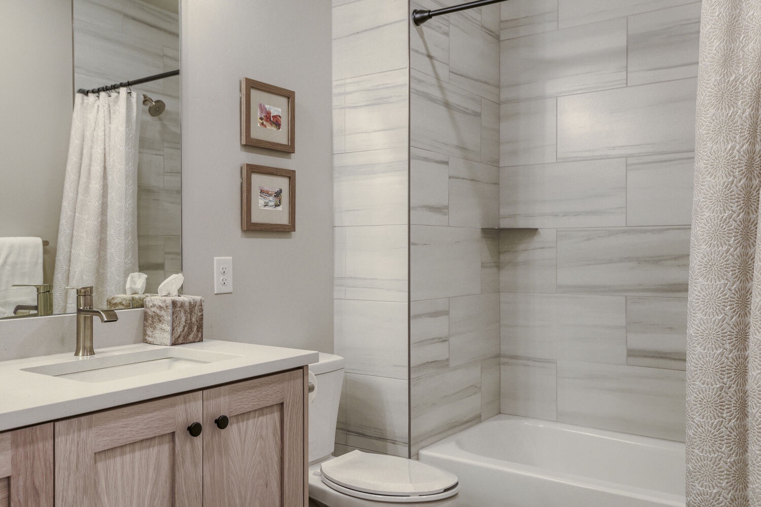 Your private bathroom features soft neutral tones, elegant tile work, and a spacious shower—perfect for refreshing after a day of adventure.