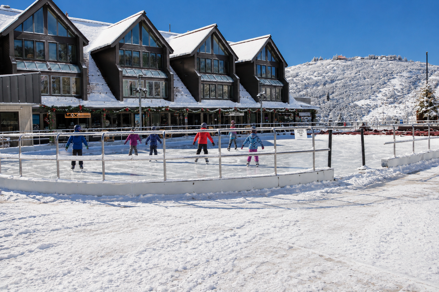 A picturesque winter village with charming snow-covered chalets, an outdoor ice rink, and stunning mountain vistas creates the perfect alpine retreat for families.