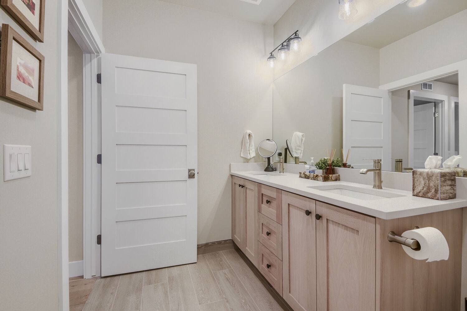 Step into your spacious bathroom with dual sinks, warm wood cabinetry, and plenty of natural light—perfect for your morning routine.