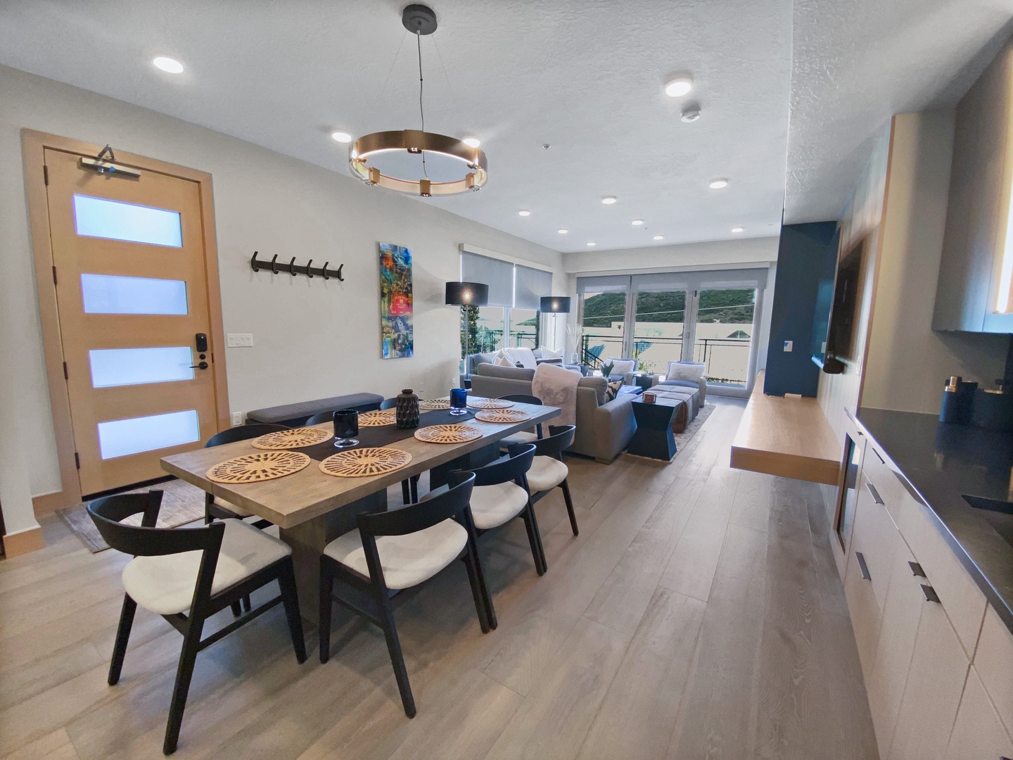 Gather around the inviting dining table, then sink into the plush living area where natural light pours through sliding doors. Your open-plan space flows seamlessly, making every moment together effortless.