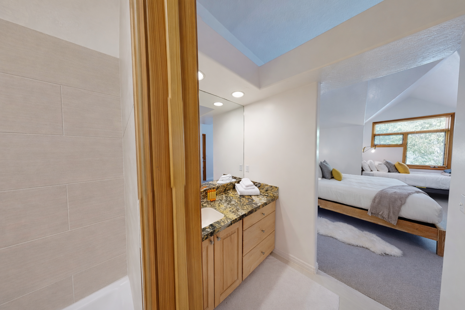 This bright, modern bathroom features a sleek double vanity with elegant stone countertops and a spacious walk-in shower, offering a refreshing start to your day.
