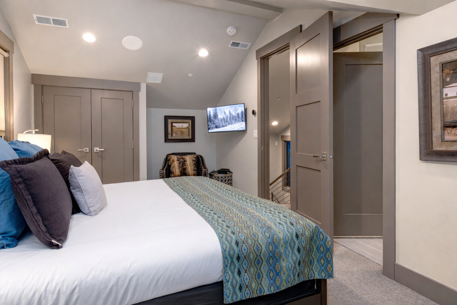 You'll love unwinding in this stylish bedroom with plush linens, wall-mounted TV, and ample storage space for your belongings.