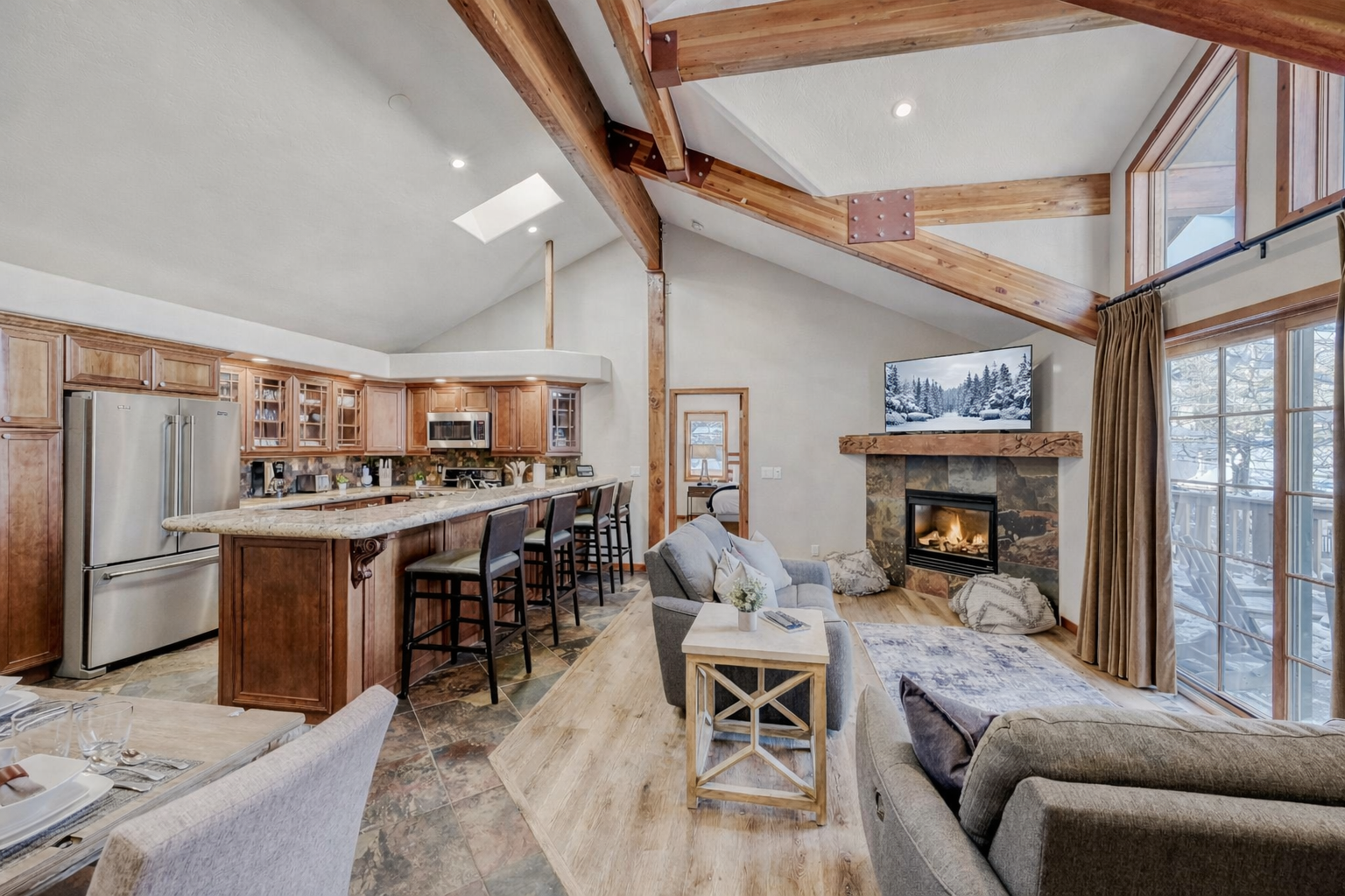 Cozy up in this stunning alpine retreat with exposed beams, crackling fireplace, and open kitchen perfect for your mountain getaway.