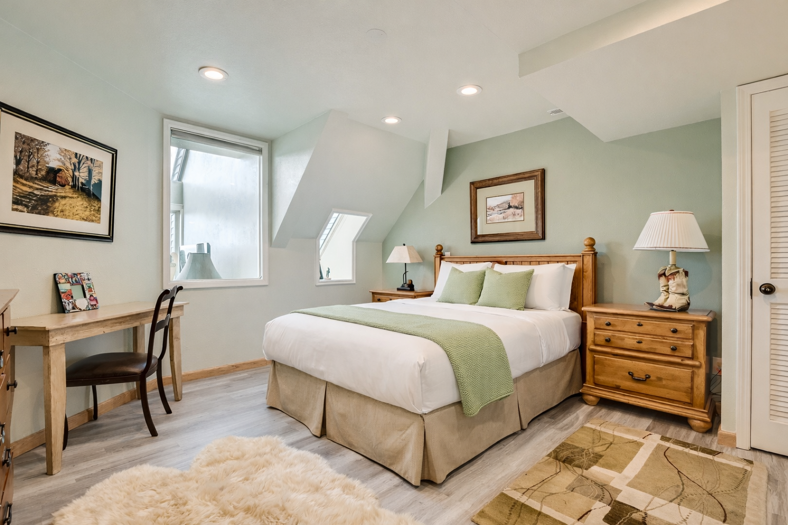 Relax in your peaceful bedroom sanctuary with soft sage walls and warm wood furnishings creating the perfect retreat.