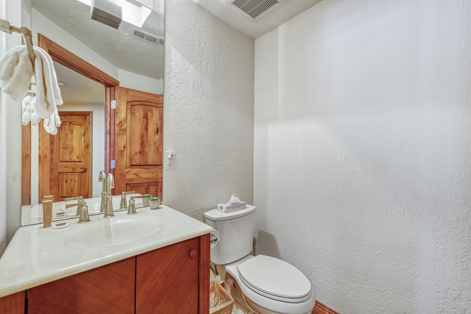 Step into your private bathroom with warm wood cabinets, fresh towels, and thoughtful amenities waiting for your comfort.