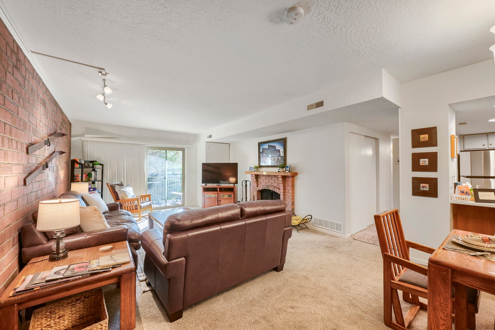 Settle into your comfortable living space where exposed brick walls and a warm fireplace create an inviting atmosphere perfect for unwinding after exploring the area.
