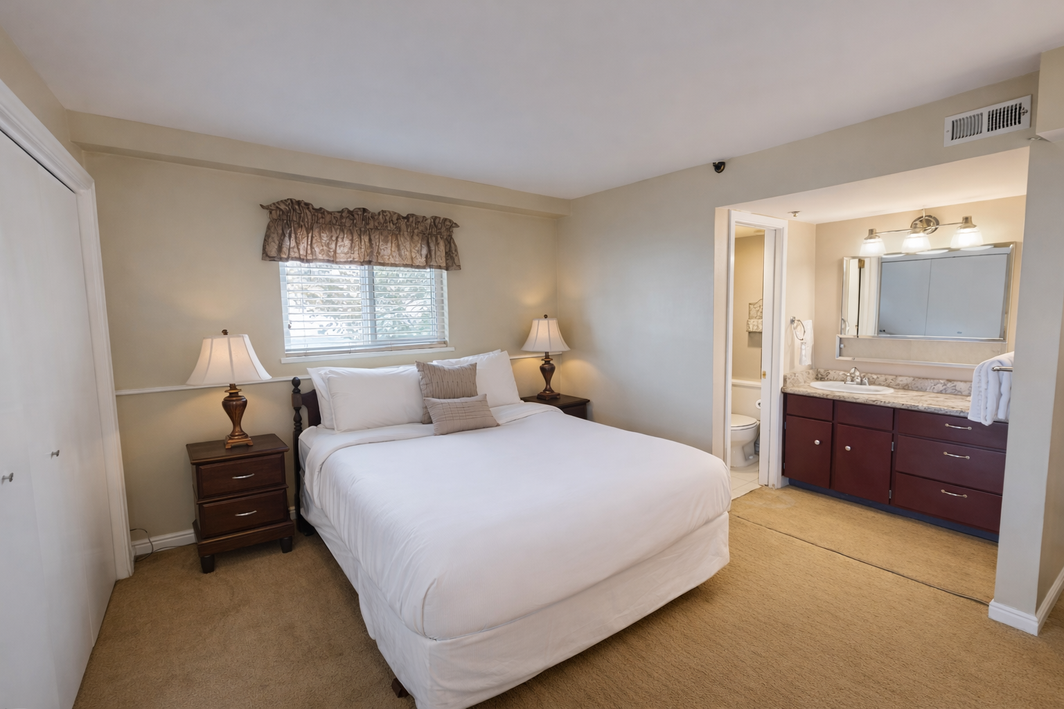 Cozy mountain retreat! Relax in this inviting king room with warm lighting, wood furniture, and an ensuite bath.