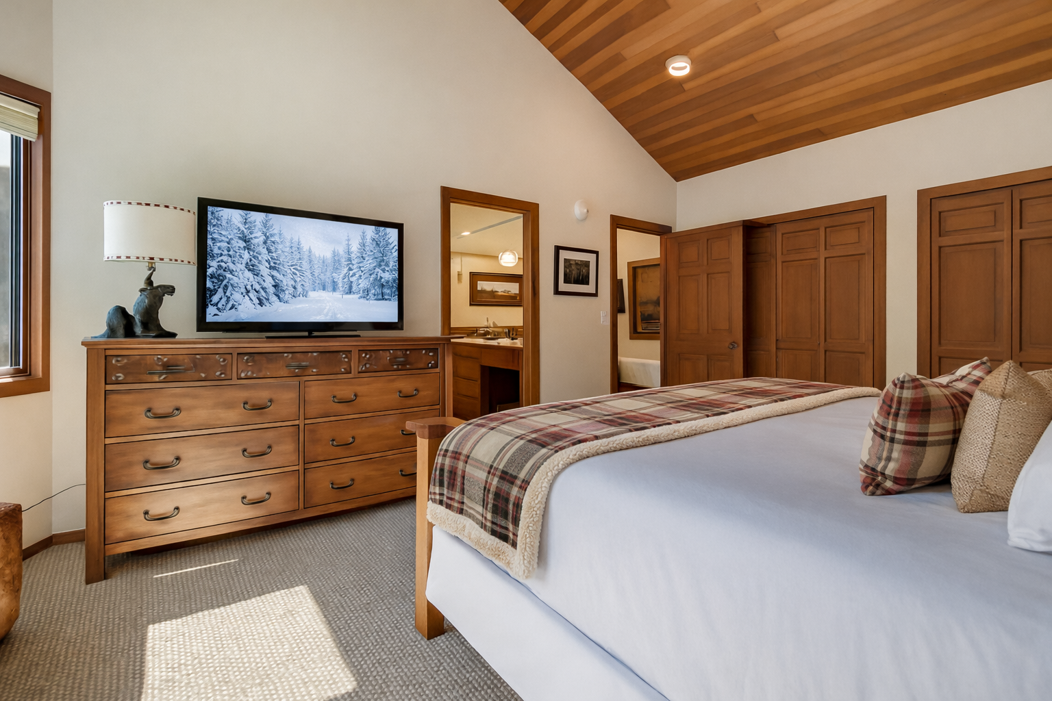 Relax in this rustic-elegant bedroom with warm wood details and cozy plaid accents creating your perfect mountain retreat sanctuary.