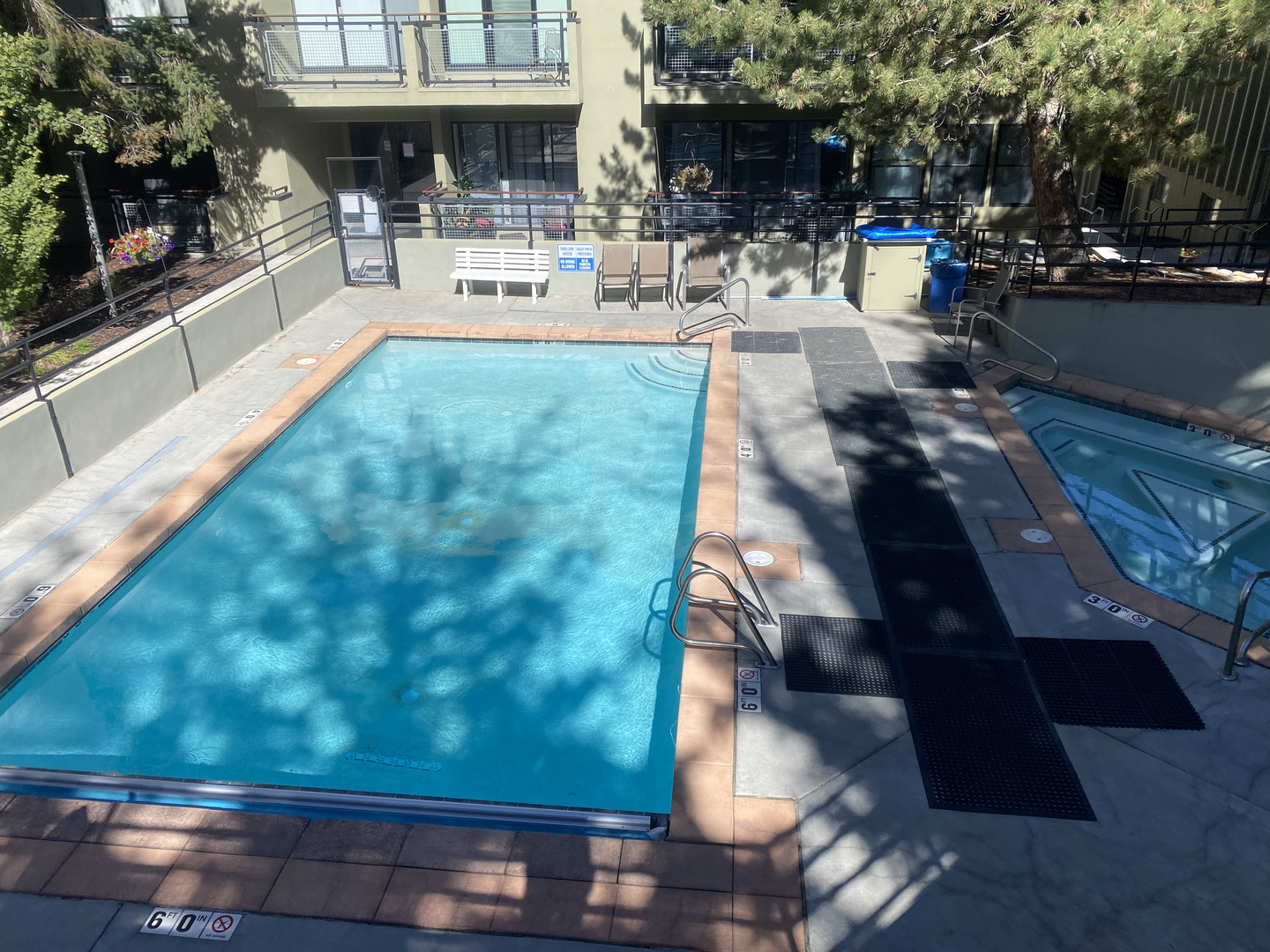 Dive into crystal-clear waters in your private pool sanctuary, surrounded by lush trees and comfortable poolside seating for ultimate relaxation.