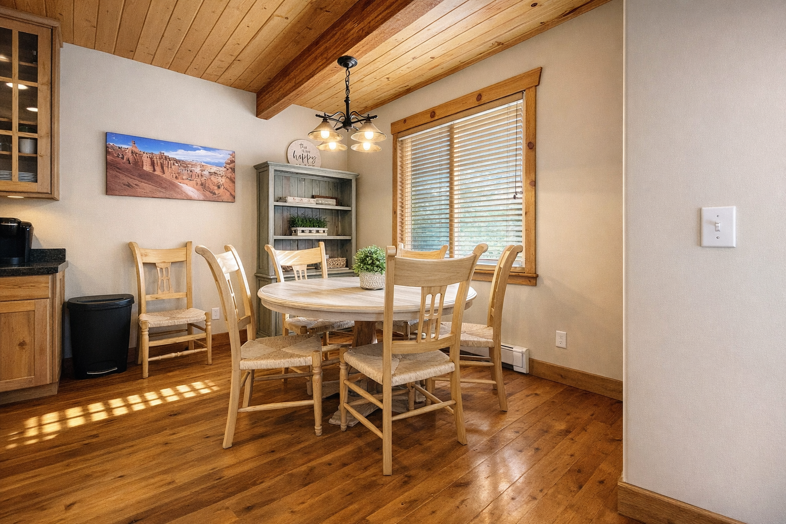 Gather for memorable meals around the cozy dining table beneath the rustic wagon wheel chandelier. The fully equipped kitchen is steps away.