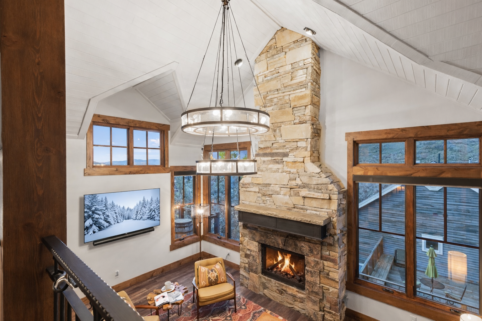 Cozy up in this stunning living room where a crackling stone fireplace and mountain views create your perfect alpine retreat.