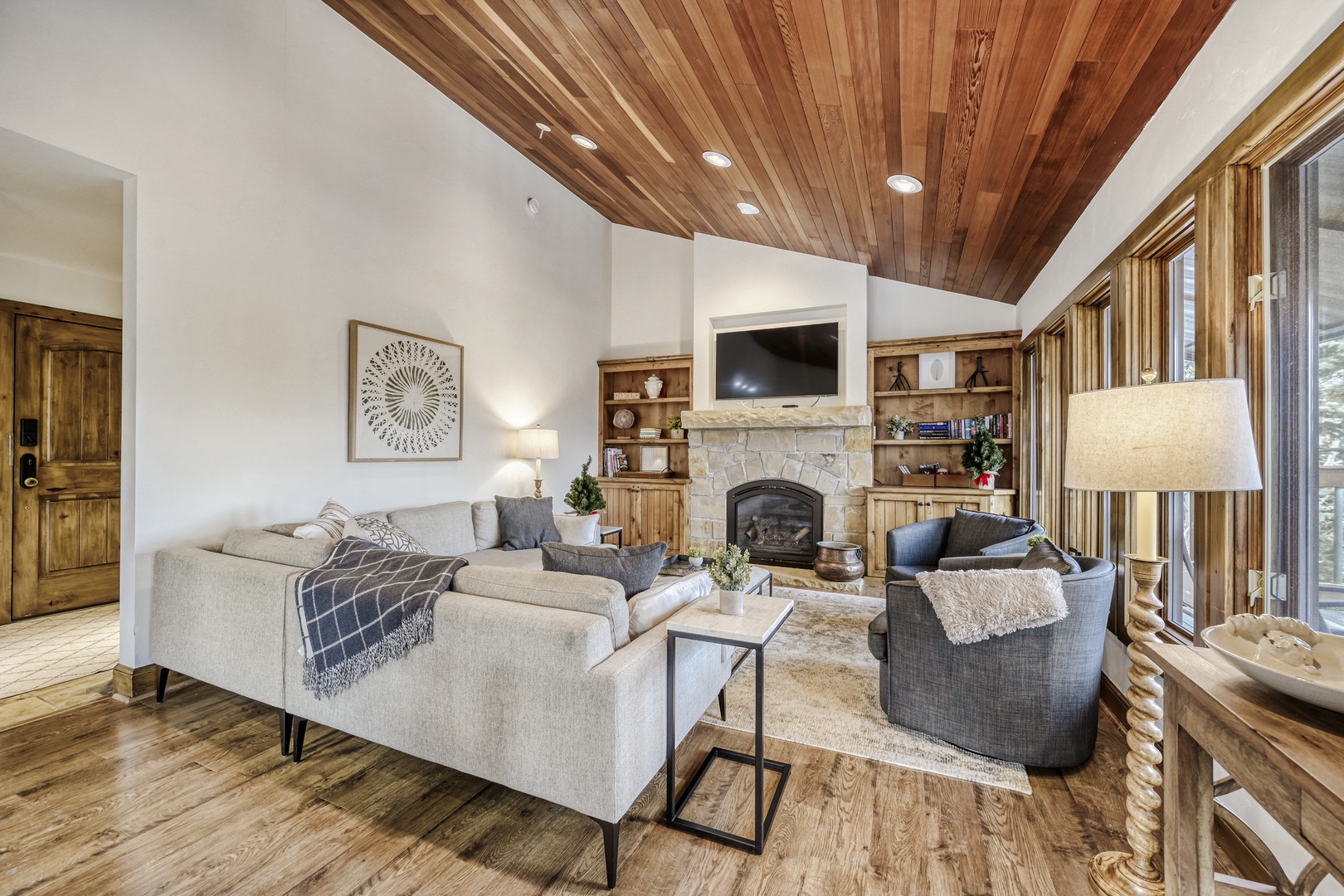 Gather with loved ones in this inviting living room, where soaring wood-beamed ceilings and a cozy stone fireplace create the perfect retreat after your mountain adventures.